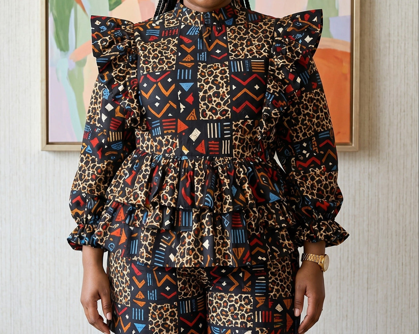 Woman wearing a colorful patterned outfit standing in front of a abstract painting.