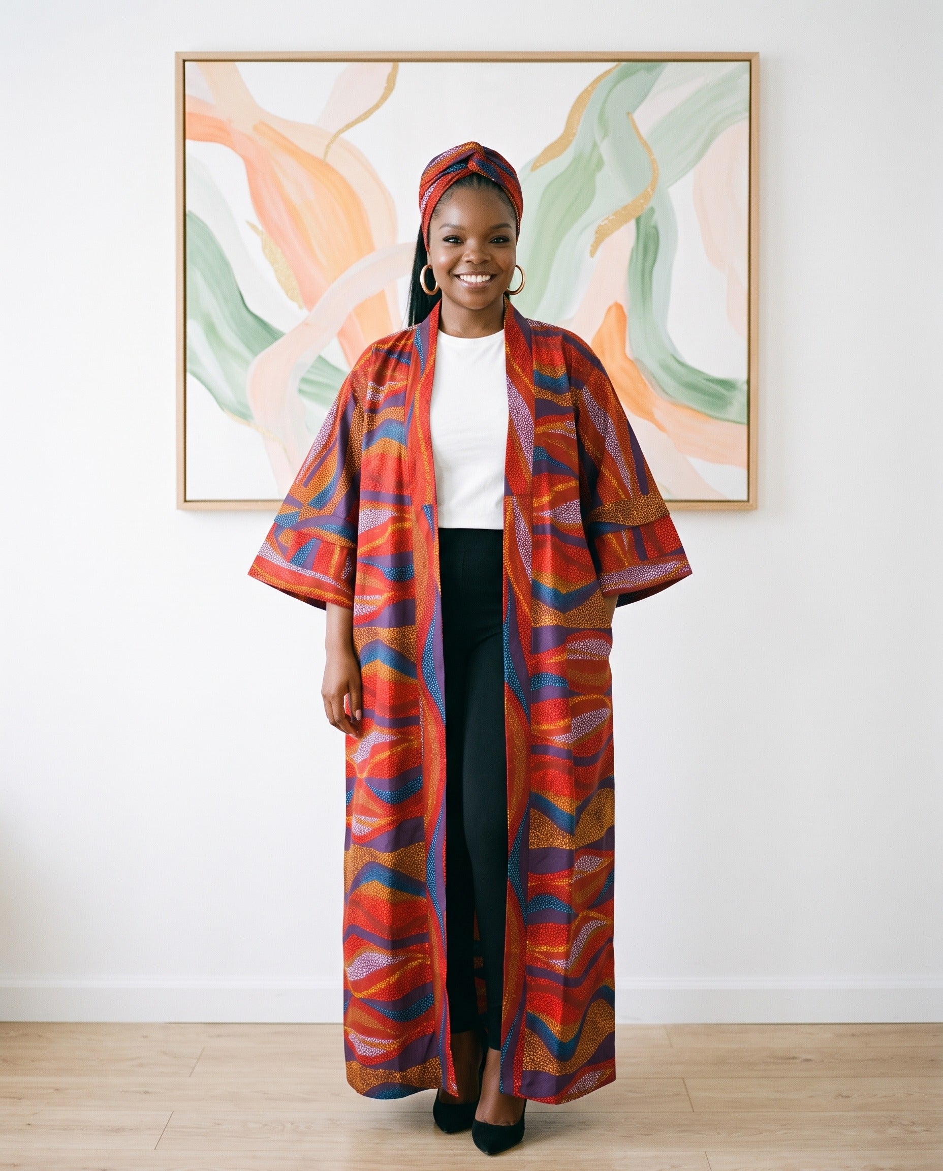 Woman wearing a colorful kimono-style garment standing in front of abstract wall art.