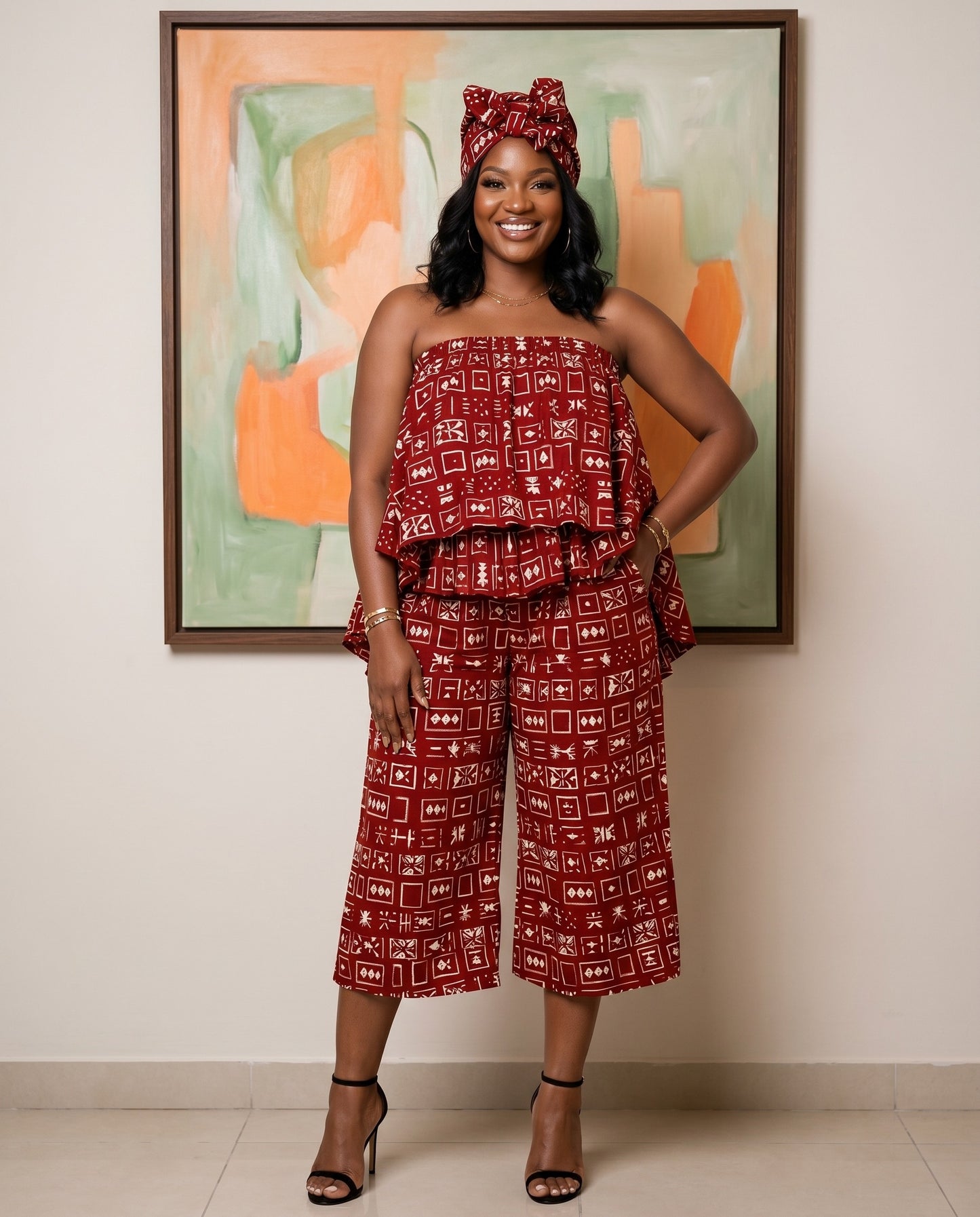 Woman in a red patterned outfit standing in front of a colorful abstract painting.