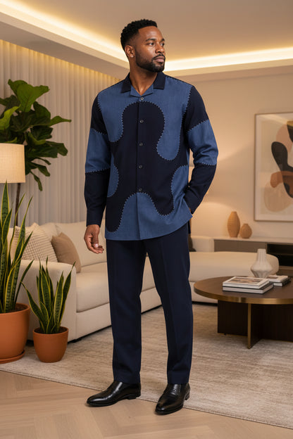 Man in a blue and navy patterned shirt standing in a modern living room.