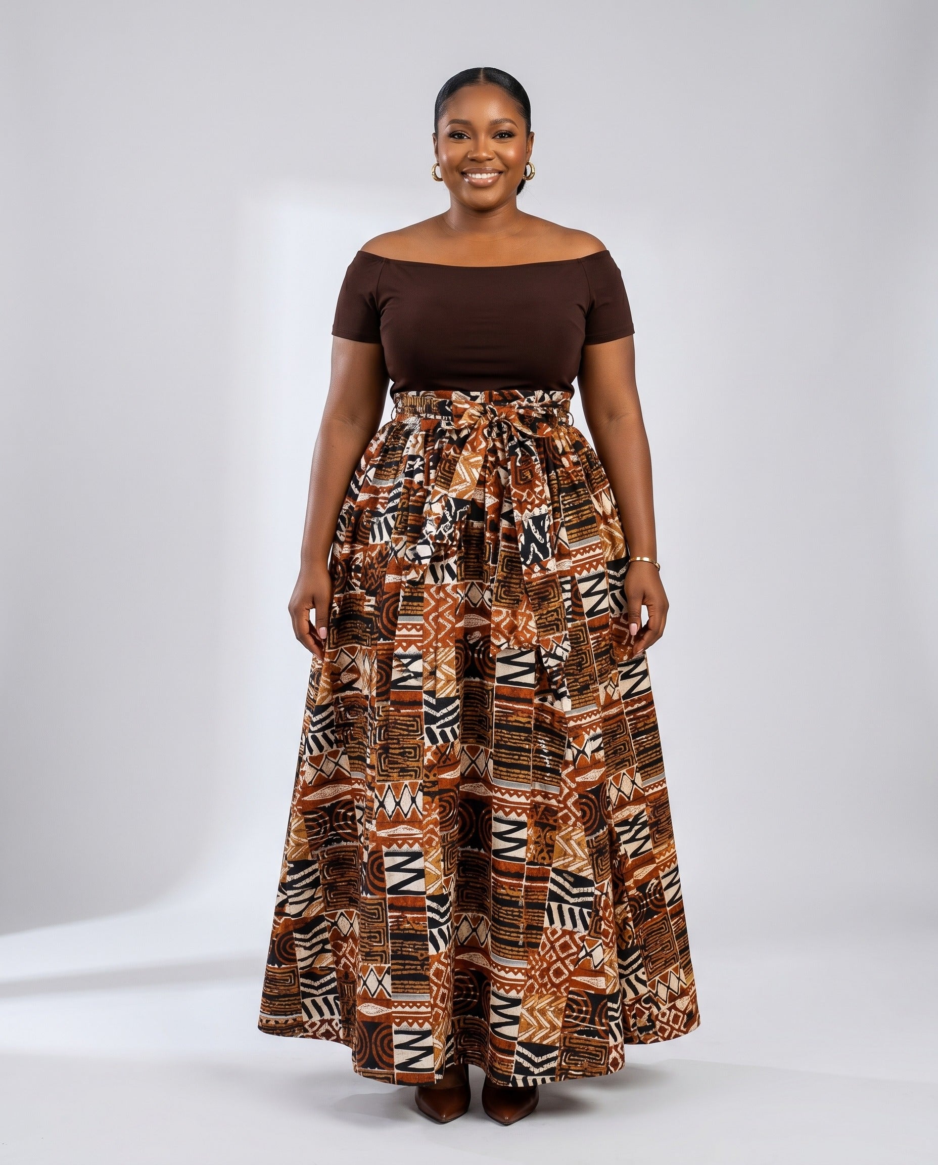 Woman wearing a brown top and patterned skirt on a white background
