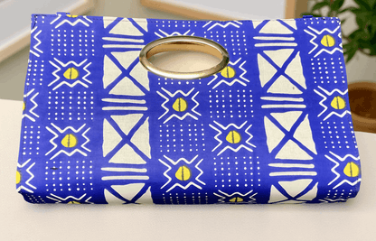 Blue and white patterned pouch with a gold ring on a light background