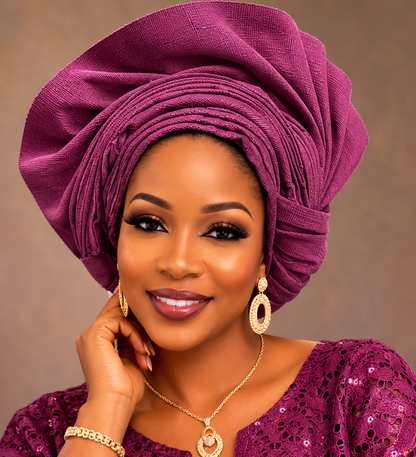 A woman wearing a voluminous plum purple fabric headwrap (afro) and a matching purple sequined top, accessorized with gold jewelry against a neutral brown background.