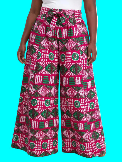 Person wearing pink and green patterned wide-leg pants on a white background
