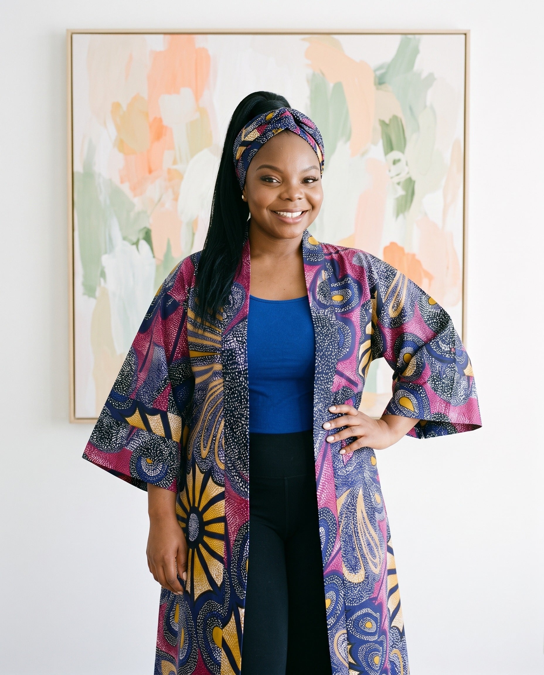 Woman wearing a colorful patterned coat in front of abstract art
