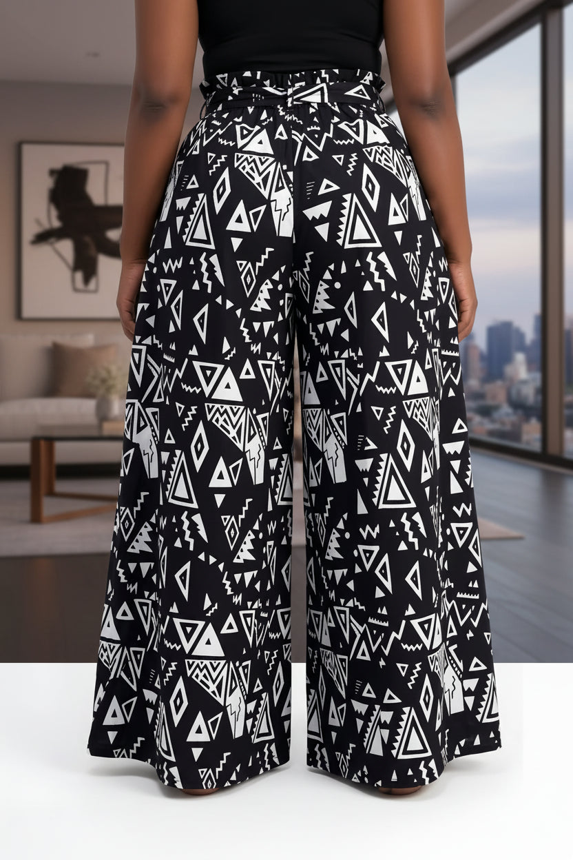 Black and white patterned wide-leg pants on a person against a white background